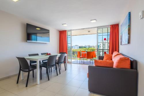 comedor con mesa y sillas en Rentalmar Navarra family suites, en Salou