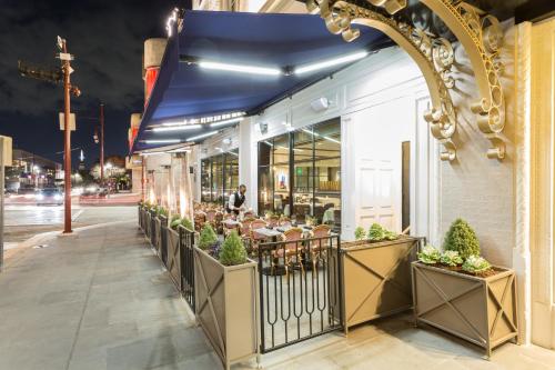 un restaurante con mesas y sillas frente a un edificio en The Lancaster Hotel, en Houston