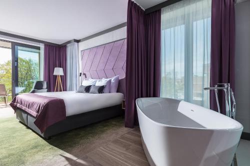 Schlafzimmer mit einem Bett, einer Badewanne und einer Badewanne in der Unterkunft Gwiazda Morza Resort SPA&SPORT in Władysławowo