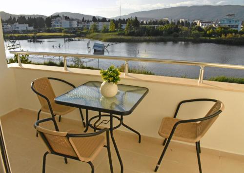 einen Tisch und Stühle auf einem Balkon mit Flussblick in der Unterkunft Beach Walk Apartments in Ulcinj