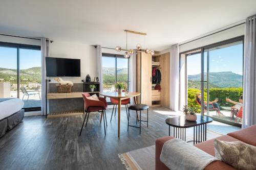 uma sala de estar com um sofá, uma mesa e cadeiras em Hotel & Spa des Gorges du Verdon em La Palud sur Verdon