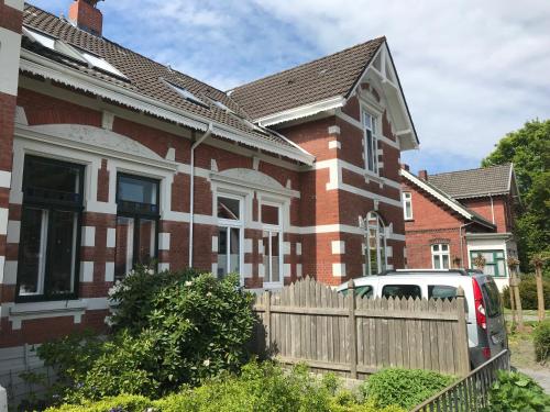 een rood bakstenen huis met een wit busje aan de voorkant bij Stadtvilla Stöhr in Norden