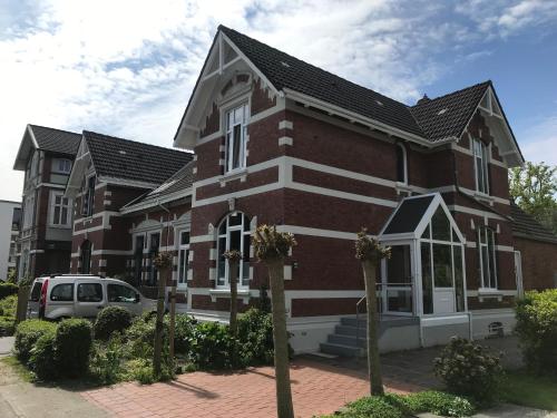 een bakstenen gebouw met een auto ervoor geparkeerd bij Stadtvilla Stöhr in Norden