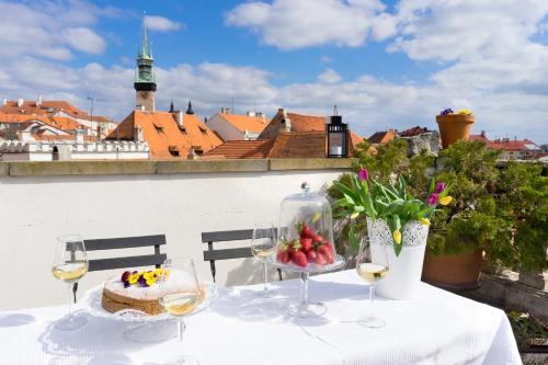 uma mesa com um bolo e taças de vinho em Boutique Apartments U Rolanda, Mikulášské náměstí em Znojmo