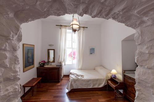 um quarto com uma cama e uma janela em Hotel Miranda em Hydra