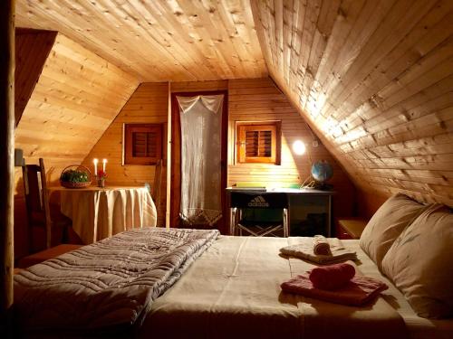 een slaapkamer met een groot bed in een houten kamer bij Villa ORKA Pelister - Forest Zone in Bitola