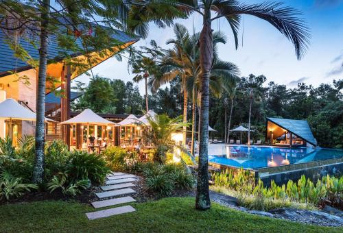 um resort com piscina e palmeiras em Niramaya Villas and Spa em Port Douglas