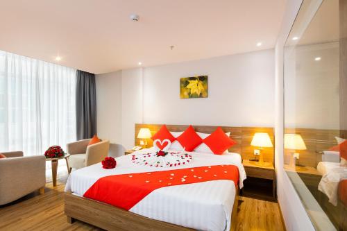 una habitación de hotel con una cama grande con almohadas rojas en Maple Leaf Hotel & Apartment, en Nha Trang