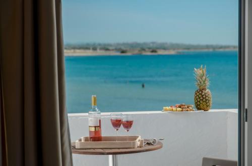 einen Tisch mit Weingläsern und Strandblick in der Unterkunft Prestige on the beach in Naxos Chora