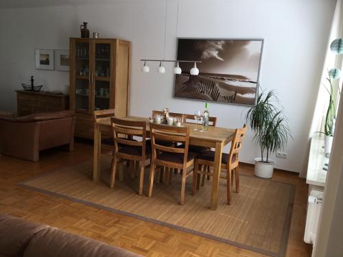 een eetkamer met een houten tafel en stoelen bij Ferienhaus Am Yachthafen in Rendsburg