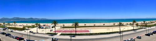 ein Parkplatz mit Autos neben dem Strand in der Unterkunft Edifici Valeria in Empuriabrava