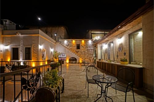 an outdoor patio with tables and chairs at night at Mira Cappadocia Hotel in Avanos