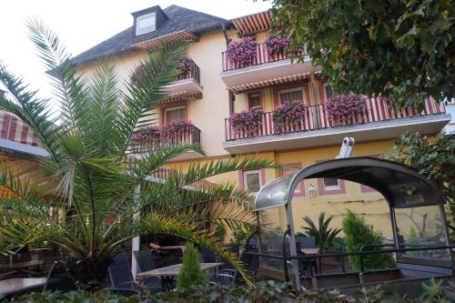 un bâtiment avec des tables et des chaises devant lui dans l'établissement Hotel Rüdesheimer Hof - Superior, à Rüdesheim am Rhein