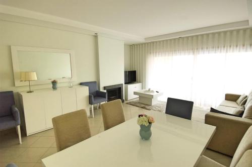 uma sala de estar com uma mesa com um vaso de flores em Vilamoura Condominio do Pinhal em Vilamoura