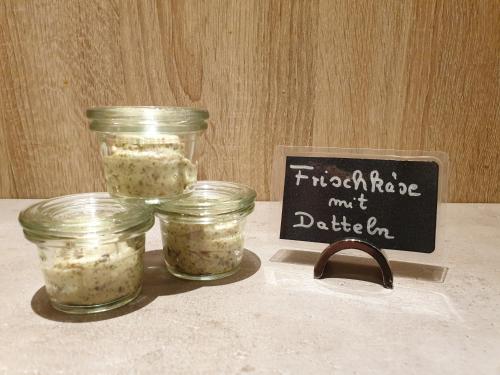 three jars of food sitting on a table next to a sign at Komforthotel Butjadinger Tor in Nordenham