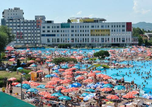 a large crowd of people at a beach with umbrellas at Hollywood Hotel in Sarajevo