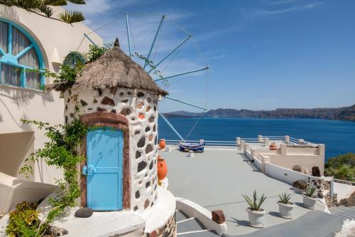 a door on the side of a building with a view of the water at Kokkinos Villas in Akrotiri