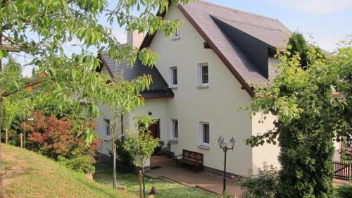 een wit huis met een bruin dak bij Ferienwohnungen Oberwiesenthal in Kurort Oberwiesenthal