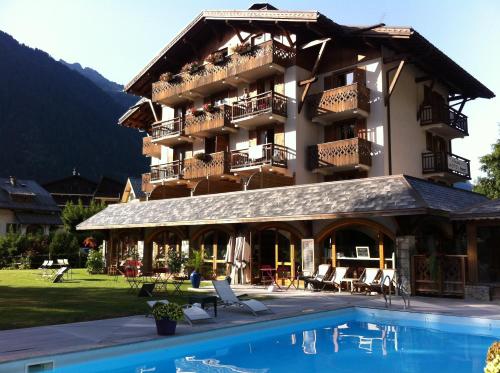 um hotel com piscina em frente a um edifício em Oustalet em Chamonix-Mont-Blanc