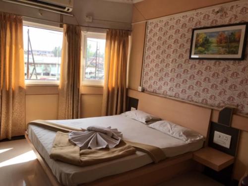 - une chambre avec un grand lit et une fenêtre dans l'établissement Bharati Lodge, à Hubli