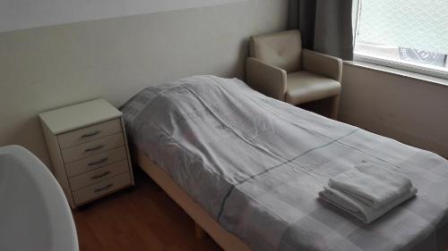 una piccola camera con letto e sedia di Bed & Breakfast Vlissingen a Vlissingen