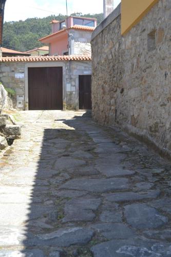 Une allée en pierre avec un bâtiment et un portail dans l'établissement Quinta do Real - Casa de Campo, à Viana do Castelo