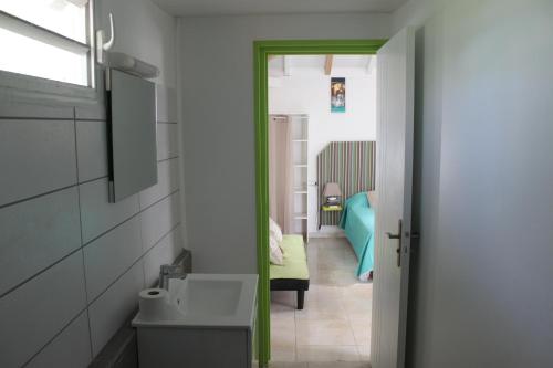 een badkamer met een deur naar een slaapkamer bij Résidence B&L Lagon : Bungalow Atoll in Sainte-Luce