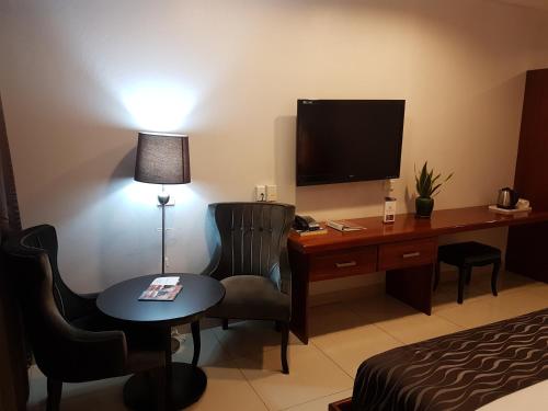 Habitación de hotel con escritorio, ordenador y cama en PADDY'S HOTEL & APARTMENTS, en Port Moresby