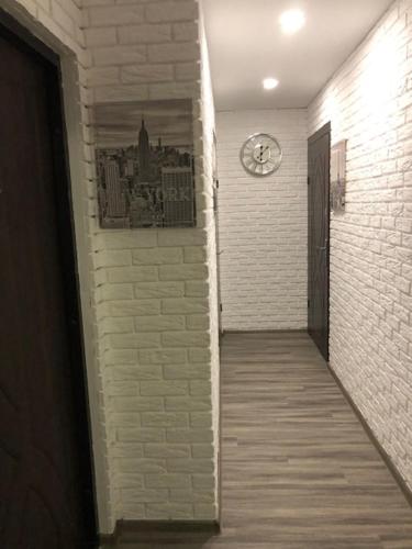 a hallway with a clock on a brick wall at Smart Studio New York 2 in Irpin'