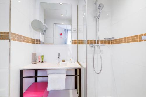 a bathroom with a sink and a shower at Hôtel Augustin - Astotel in Paris