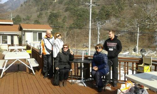 un gruppo di persone che posano per una foto su un ponte di Fermata Pension a Pyeongchang