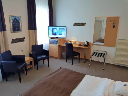 - une chambre avec un bureau, des chaises et une télévision dans l'établissement Hotel zum Anker, à Andernach