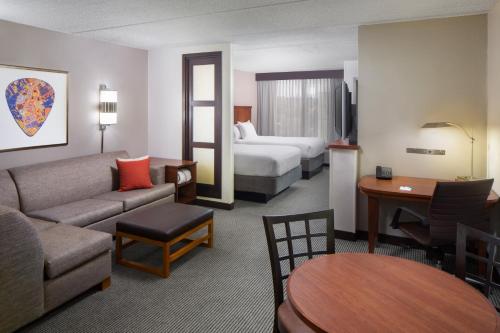 a hotel room with a couch and a bed at Hyatt Place Dallas/North Arlington/Grand Prairie in Arlington