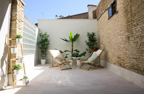 un patio con sedie e piante in un edificio di El Oasis de la Estafeta a Pamplona