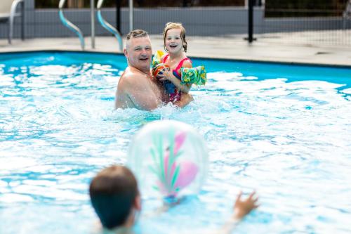 mężczyzna i dziewczynka w basenie w obiekcie TopParken - Recreatiepark Beekbergen w mieście Beekbergen