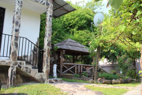 a wooden gazebo in a yard with trees at Nikala's house in Borjomi