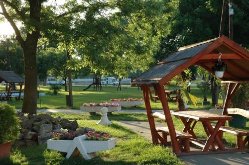 een park met een houten bank en een tuinhuisje bij Szegedi Partfürdő Kemping és Apartman in Szeged