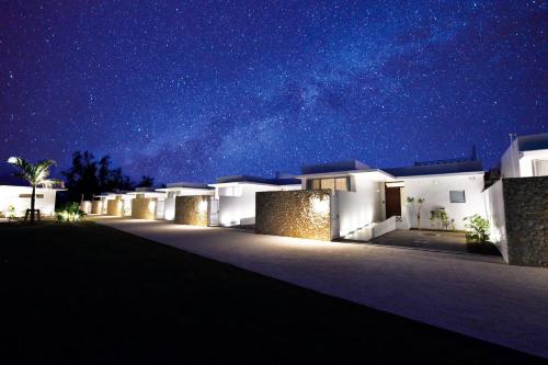 eine Reihe von Häusern in der Nacht mit Sternenhimmel in der Unterkunft Feliz Villa Suite Irabujima Sawada in Miyako-jima