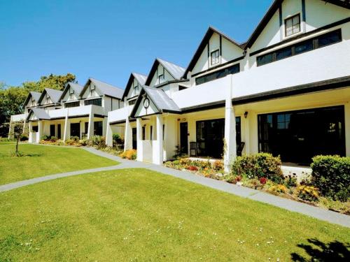 een groot huis met een gazon ervoor bij Salty Dog Inn in Snells Beach