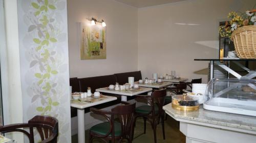 a dining room with tables and chairs and a counter at Entrée Groß Borstel Garni Hotel in Hamburg