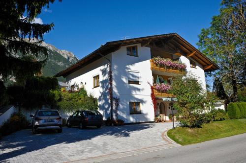 ein weißes Haus mit davor geparkt in der Unterkunft Landhaus Doris in Leutasch