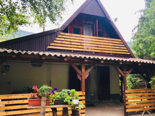 een huis met een veranda met potplanten erop bij Villa ORKA Pelister - Forest Zone in Bitola