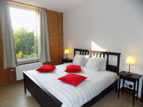 um quarto com uma cama grande com almofadas vermelhas em Maison Roosevelt - Charleroi Airport - Ideal Families em Charleroi