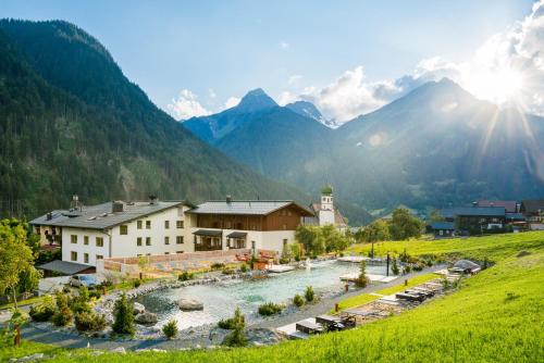 un pueblo con un río y montañas en el fondo en Hotel Gasthof Adler, en Sankt Gallenkirch