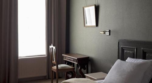 - une chambre avec un bureau, un lit et une chaise dans l'établissement Boutique hotel Sint Jacob, à Maastricht