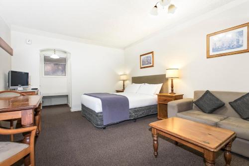 ein Hotelzimmer mit einem Bett und einem Sofa in der Unterkunft Hotel Bruce County in Mount Waverley