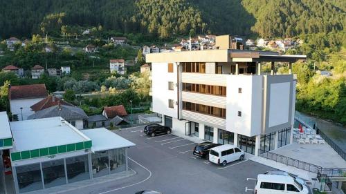 een groot gebouw met auto's geparkeerd op een parkeerplaats bij Hotel Novalić Konjic in Konjic