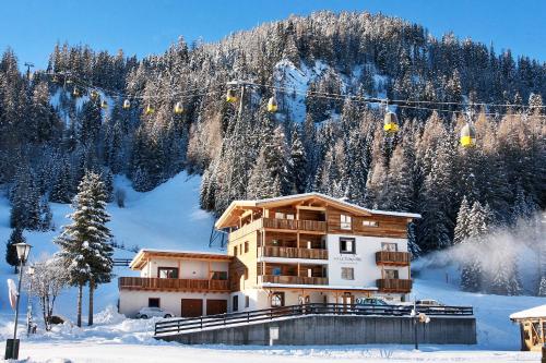 un edificio en la nieve con un remonte en B&B La Tranquillitè, en Corvara in Badia