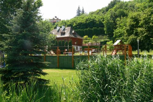 een huis in het midden van een tuin met een boom bij Dworek Karpińskich in Sandomierz