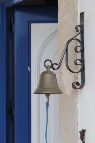 um sino pendurado numa parede ao lado de uma porta em Monte do Parral em Santiago do Cacém